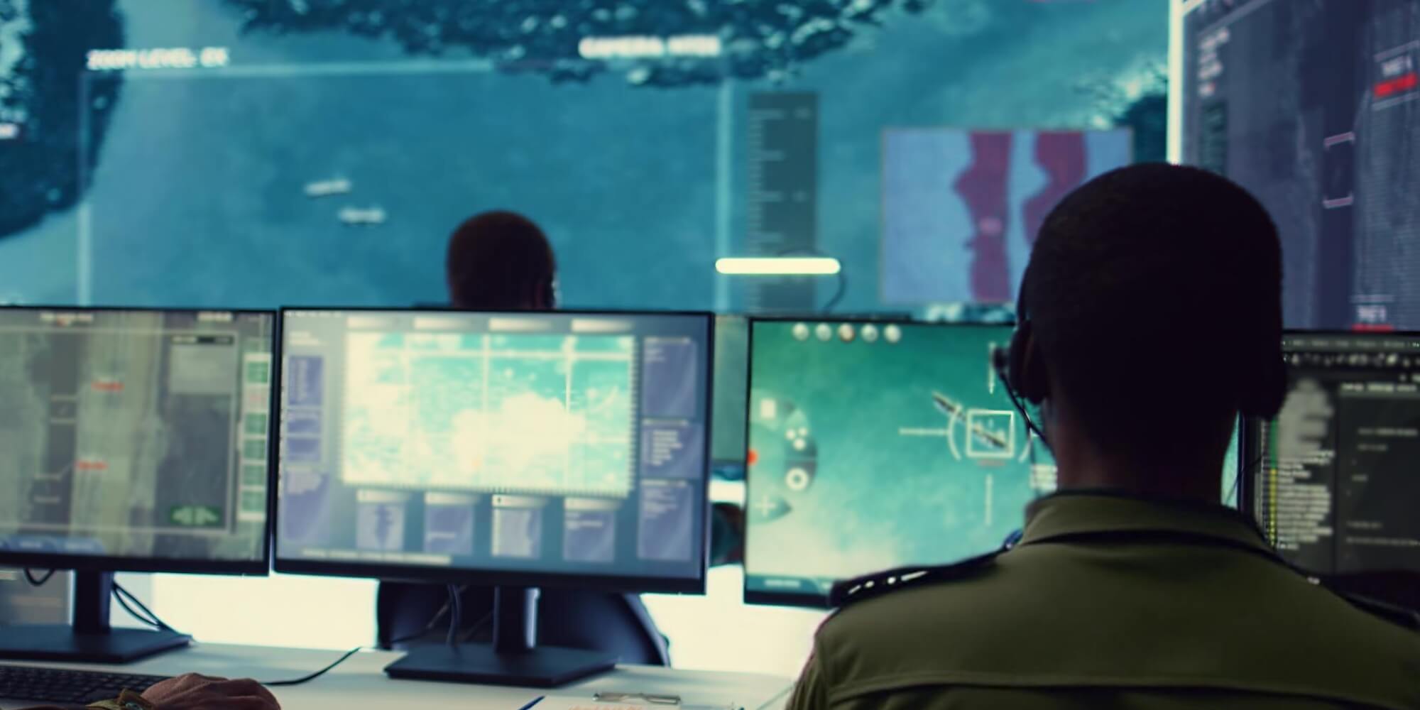 חיילים במרכז שליטה מודיעיני עם מסכים מרובים, מפקחים על פעילות מבצעית בזמן אמת